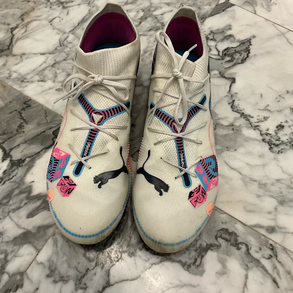 Puma Men’s White soccer cleats with blue, orange, black, and and pink Accents